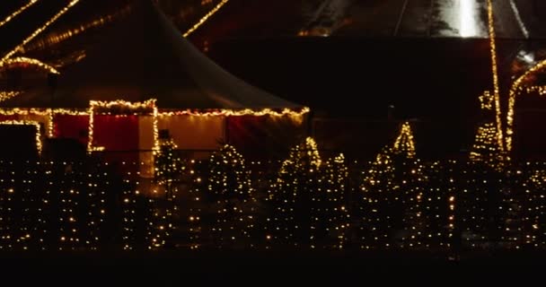 Świąteczne światła ustawione wokół płotu i markizy z choinką — Wideo stockowe