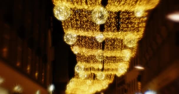 Gece şehrin üzerinde parıldayan altın Noel ışıkları ayarlandı. — Stok video