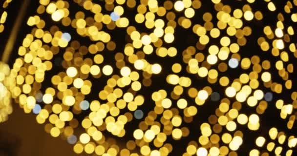 夜空に輝く黄金のクリスマスライトの焦点を絞ったショット — ストック動画