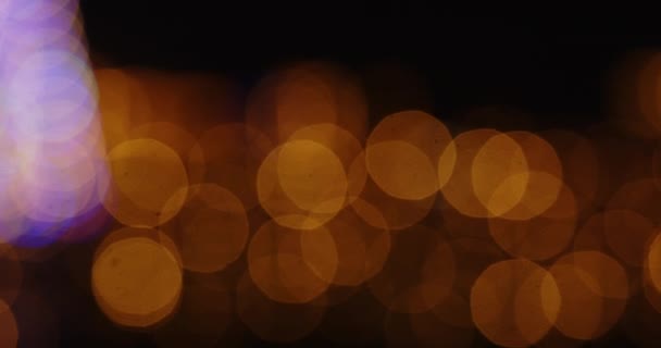 Luzes de Natal desfocadas contra fundo preto — Vídeo de Stock