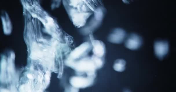 Woda wlana do cieczy tworząc powstające niebieskie pęcherzyki — Wideo stockowe