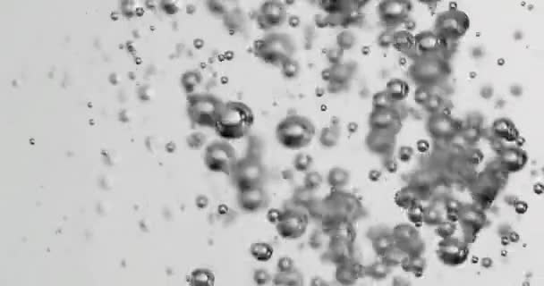 Folyadékot öntenek a vízbe, ami növekvő buborékokat okoz — Stock videók