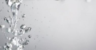 Suyun içine sıvı dökülürken kabarcıklar yükseliyor.