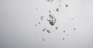 Suyun içine sıvı dökülürken kabarcıklar yükseliyor.