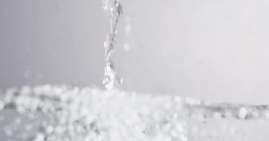 Su yüzeyine dökülen su, sıçrama ve kabarcıklar oluşturur.