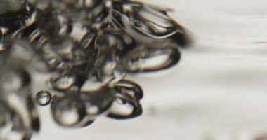 Kabarcıklar hareketli bir su yüzeyine yükseliyor.