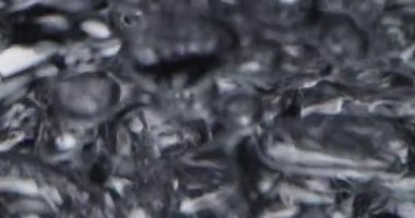 Gümüş kabarcıklar hareketli bir su yüzeyine yükseliyor