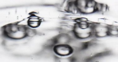 Kabarcıklar hareketli bir su yüzeyine yükseliyor.