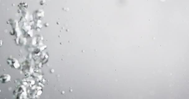 Bulles qui montent dans l'eau à mesure que le liquide y est versé — Video