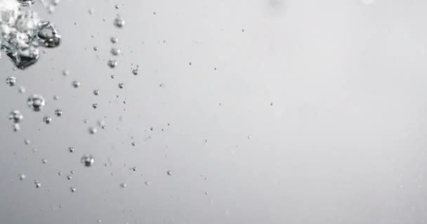 Bubbles emelkedik a vízben, mint folyadék öntjük bele — Stock videók