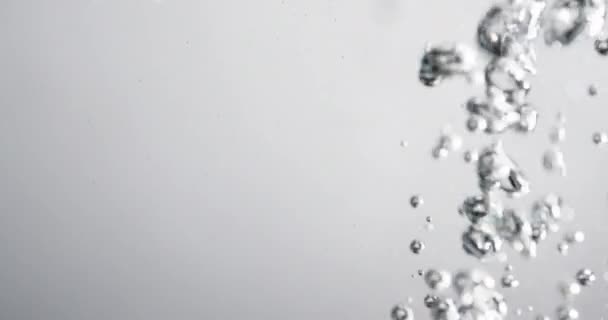 Пузыри, растущие в воде, когда в нее заливают жидкость — стоковое видео