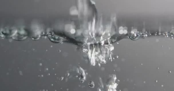 Płynne wylewanie przez powierzchnię wody i tworzenie pęcherzyków powietrza — Wideo stockowe