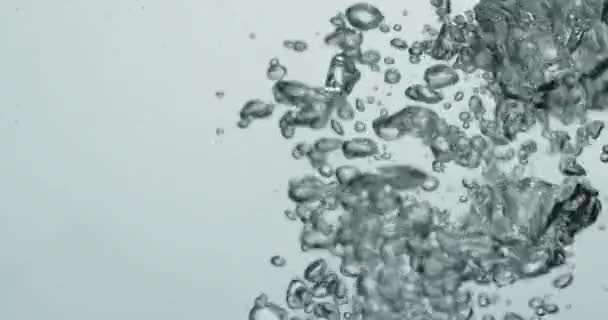 Vloeistof wordt gegoten in het water creëren van stijgende bellen — Stockvideo