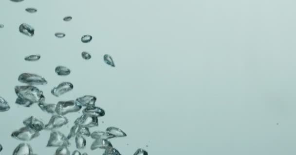 Stijgende bubbels bewegen door het water tegen witte achtergrond — Stockvideo