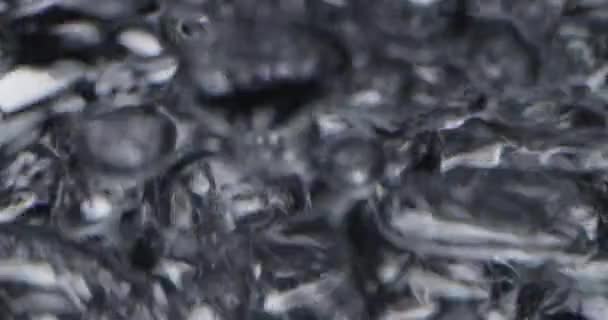 Серебряные пузыри, несущиеся к движущейся поверхности воды — стоковое видео