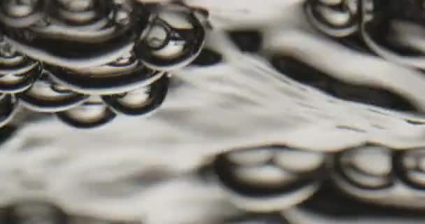 Φυσαλίδες ανεβαίνει σε μια κινούμενη επιφάνεια του νερού και την κοπή — Αρχείο Βίντεο