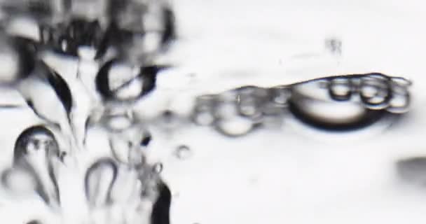 Bubliny stoupající na pohybující se hladinu vody a praskání — Stock video