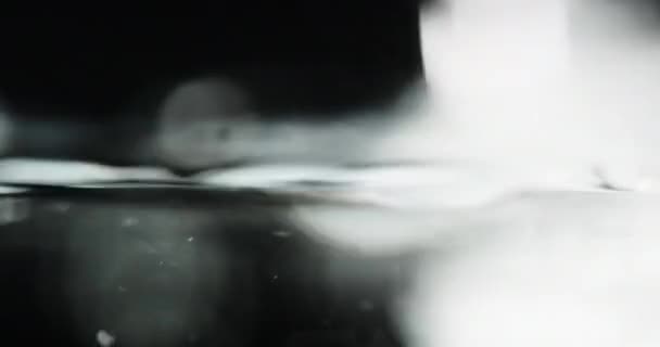 Liquid Surface Disturbed By Pouring Water With Bubbles Rising — Stockvideo