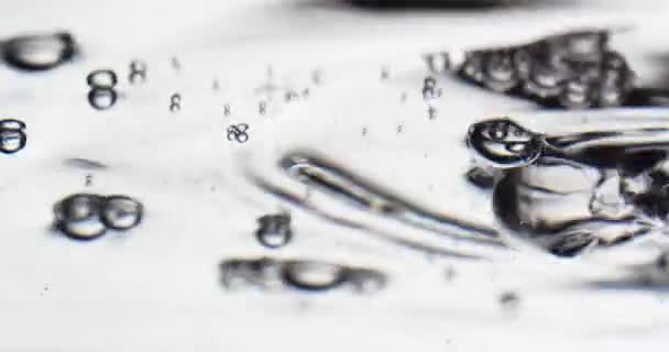Κλείδωμα πυροβόλησε φυσαλίδες επιπλέουν στην επιφάνεια του νερού σε λευκό φόντο — Αρχείο Βίντεο