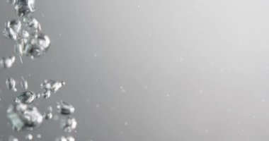 Beyaz arka plana karşı suda kabarcıklar hareket ediyor ve yükseliyor