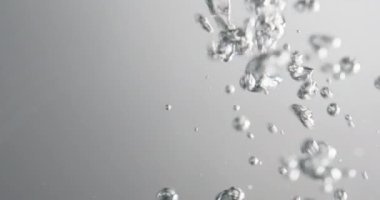 Beyaz arka plana karşı suda kabarcıklar hareket ediyor ve yükseliyor