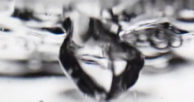 Sıvı suya döküldü. Yüzeye yükselen kabarcıklar oluşturdu.