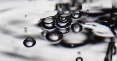 Sıvı suya döküldü. Yüzeye yükselen kabarcıklar oluşturdu.