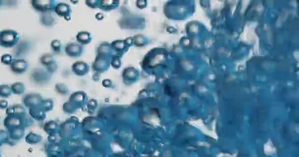 Голубые пузыри, возникающие в воде, когда жидкость заливается — стоковое видео