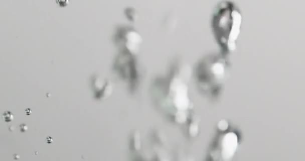 泡が立ち上がる水に液体を注ぐ — ストック動画