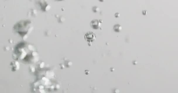 Liquide versé dans l'eau avec des bulles montant — Video