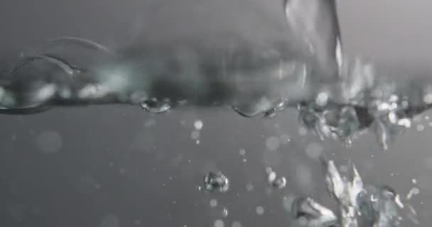 Superficie del agua con burbujas aumentando y formando como líquido se agrega — Vídeos de Stock