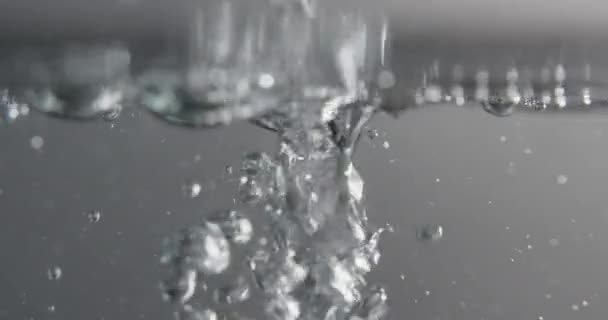 Superficie del agua con burbujas aumentando y formando como líquido se agrega — Vídeos de Stock