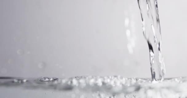 液体に注ぎ込まれる水の表面レベルショット — ストック動画