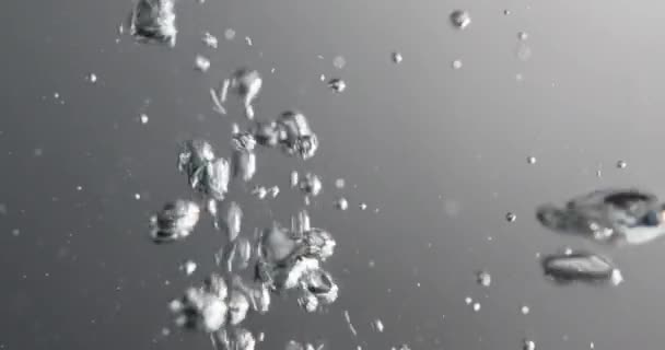 Бульбашки формуються і піднімаються як рідина додається до води — стокове відео
