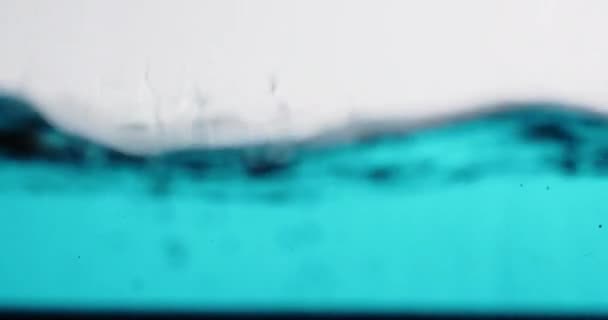 Povrch vody stoupá nahoru a dolů s bublinami a stříkancemi — Stock video