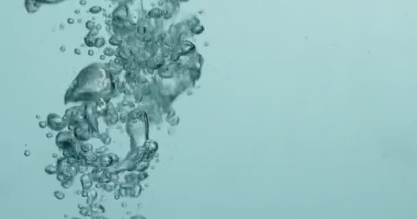 Flüssigkeit, die ins Wasser gegossen wird, erzeugt aufsteigende Blasen — Stockvideo