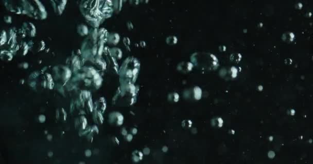 Burbujas cayendo y subiendo a través del agua — Vídeos de Stock