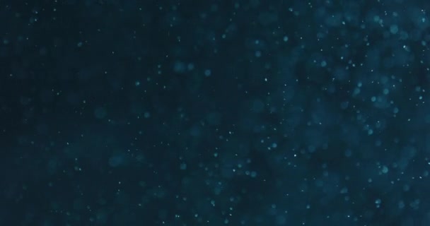 在黑色背景下水中的蓝色气泡和颗粒 — 图库视频影像