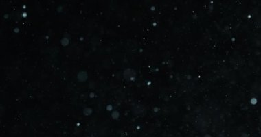 Siyah arkaplana karşı suda beyaz partiküller ve kabarcıklar