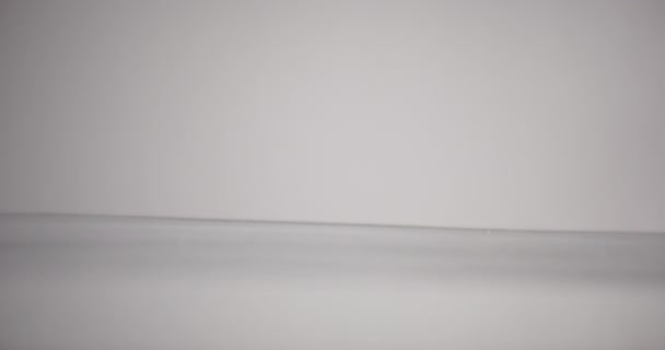 Wasseroberfläche bewegt sich vor weißem Hintergrund auf und ab — Stockvideo