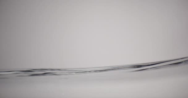 Επιφάνεια του νερού κινείται πάνω και κάτω σε λευκό φόντο — Αρχείο Βίντεο