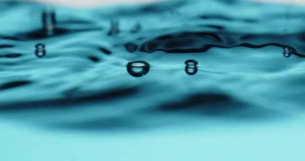 Blauw water oppervlak in beweging met bubbel barsten — Stockvideo