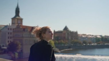 Nehrin üzerindeki manzaraya bakmak için Charles Köprüsü 'nde duran kadın