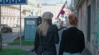 Prag 'da bir şehir sokağında yürüyen anne ve kızı.