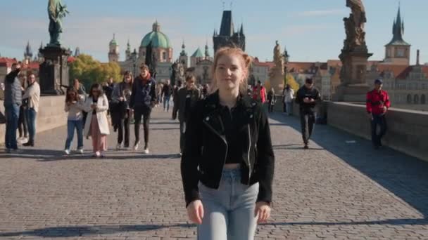 Jeune femme marchant le long du pont ensoleillé Charles — Video