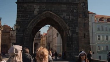Charles Köprüsü 'nde Eski Şehir Kulesi' ne doğru yürüyen turistler