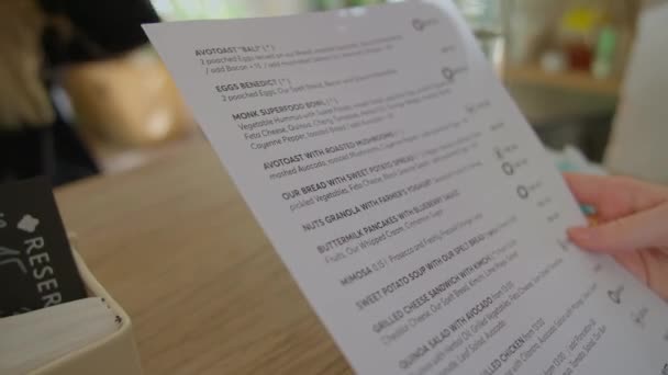 Jonge vrouw kiezen uit menu in Cafe In Praag — Stockvideo
