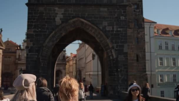 Toeristen wandelen over de Karelsbrug naar de oude stadstoren — Stockvideo