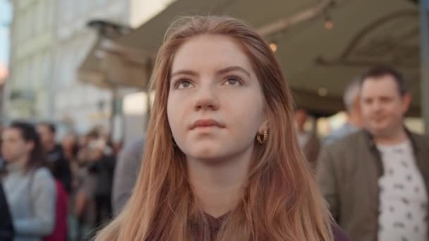 Young Woman With Long Red Hair Looking Up In Prague Town Square — Stockvideo