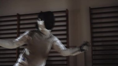 Eskrimci maskesini çıkarıyor ve gülüyor.